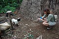 Edie plays with a goat outside of a Chaga hut.